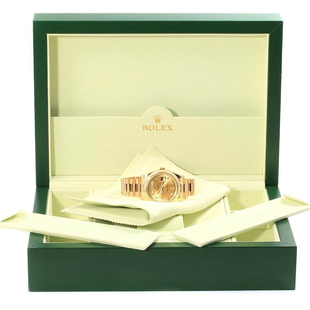 This image shows a Rolex President 218238 Men's Yellow Gold Champagne Dial 218238 Men's Yellow Gold Champagne Dial model watch in its open box with the watch displayed resting on a cloth.