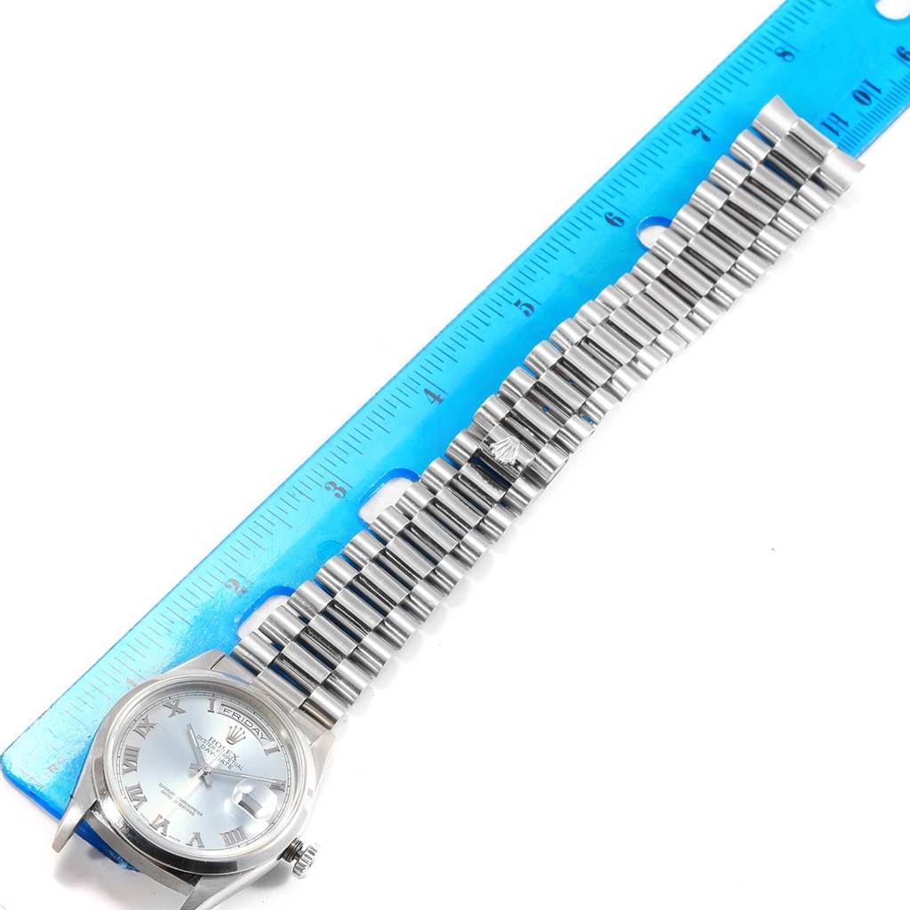 The Rolex President 18206 Men's Platinum Blue Dial 18206 Men's Platinum Blue Dial model watch is shown laid flat with a blue ruler measuring its metal bracelet.