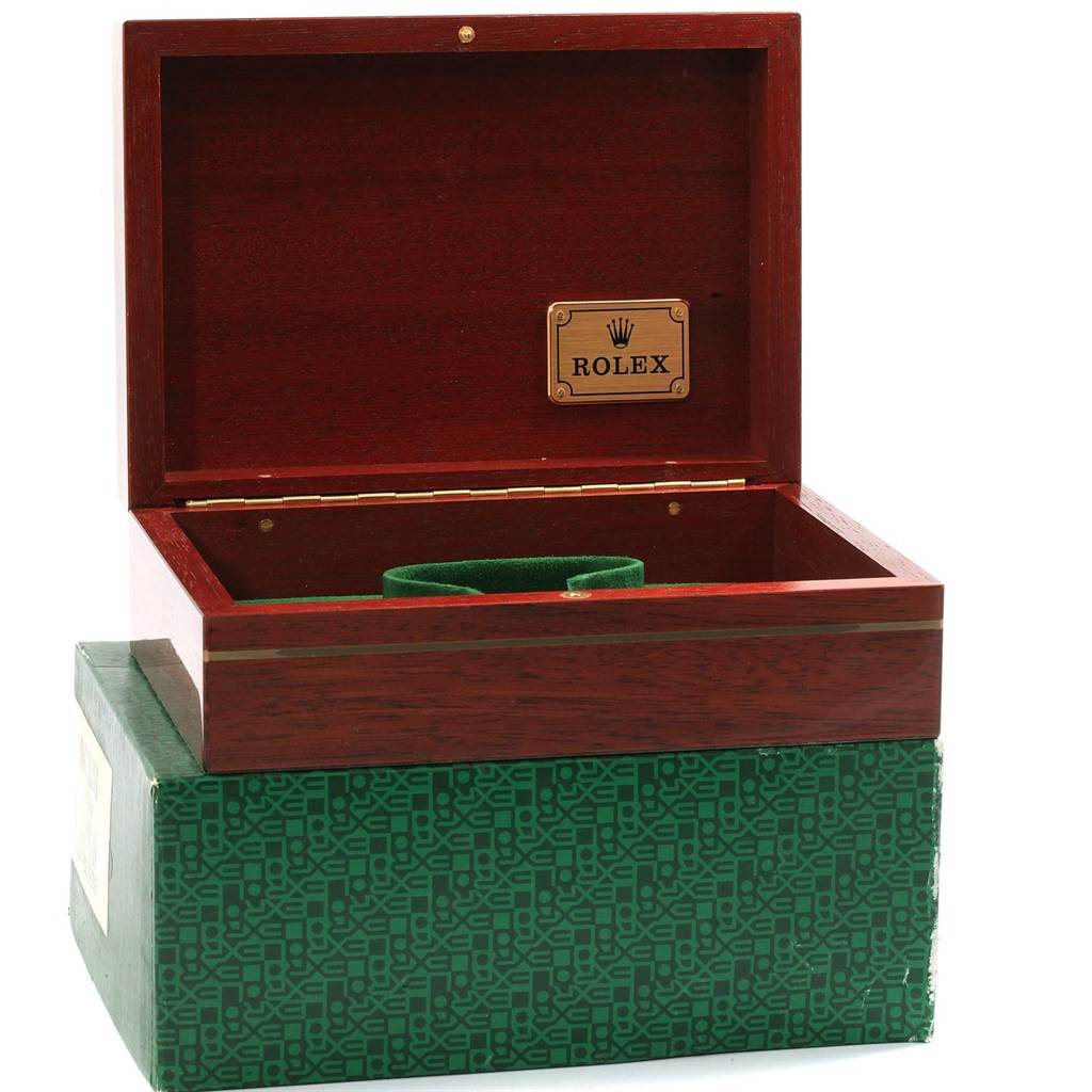 This image shows an open wooden box with a green interior and a metal plate engraved with "Rolex," designed for the President model watch by Rolex.