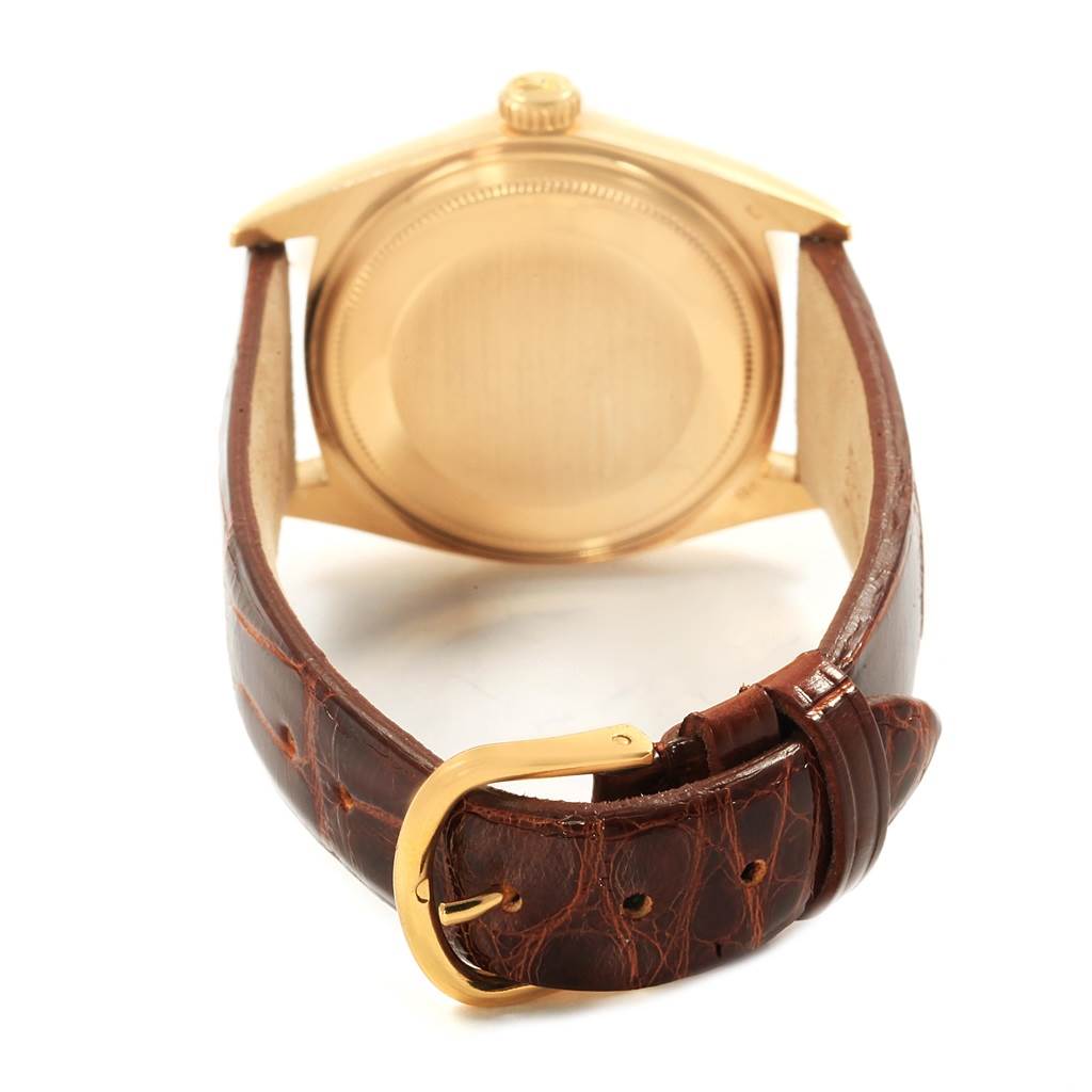 The image shows the back view of a Rolex President 1803 Men's Yellow Gold Champagne Dial 1803 Men's Yellow Gold Champagne Dial model watch, highlighting its gold case and brown leather strap with a gold buckle.