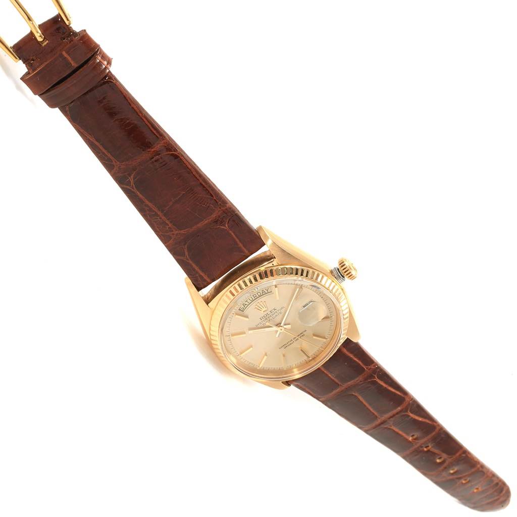 The Rolex President 1803 Men's Yellow Gold Champagne Dial 1803 Men's Yellow Gold Champagne Dial model watch is shown from a top-down angle, highlighting its gold case, dial, and brown leather strap.