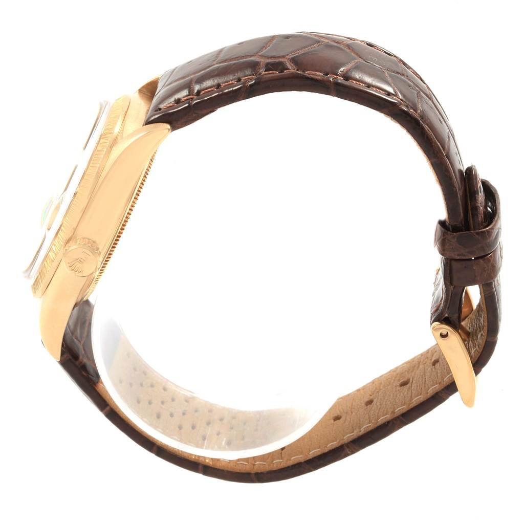 This Rolex President 1807 Men
s Yellow Gold Champagne Dial 1807 Men
s Yellow Gold Champagne Dial model watch is shown from a side angle, displaying its gold case and brown leather strap with visible stitching.