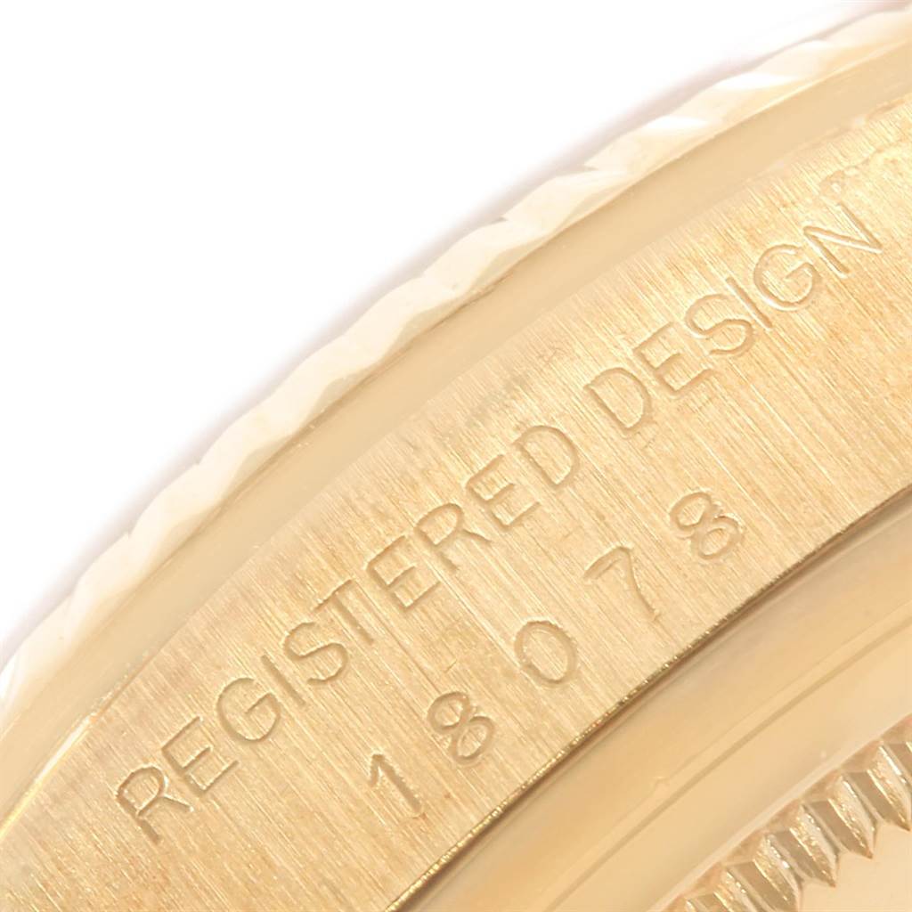 A close-up of the case side of a Rolex President 18078 Men
s Yellow Gold Black Dial 18078 Men
s Yellow Gold Black Dial model watch showing the "REGISTERED DESIGN" engraving and model number.