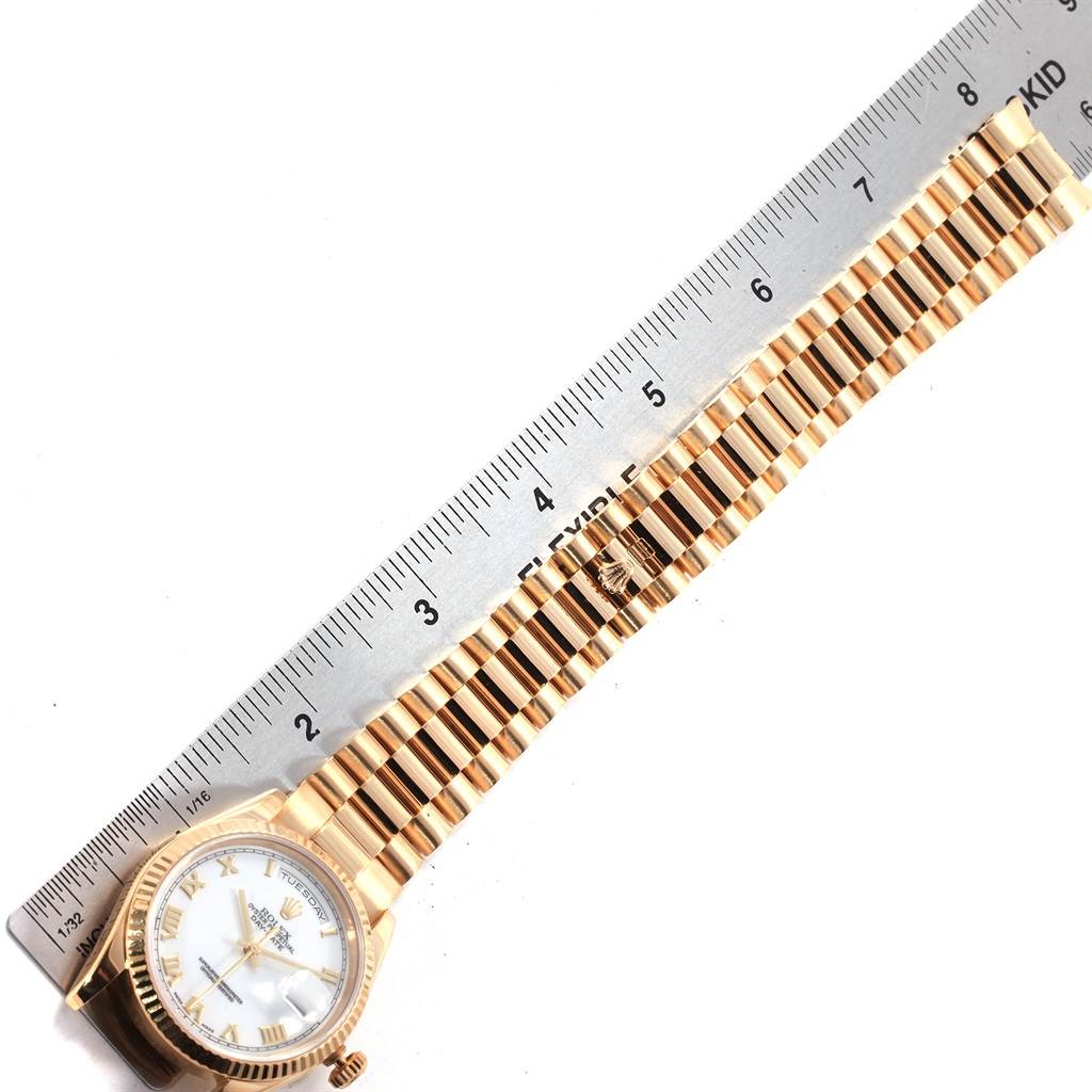 This image shows a Rolex President 118238 Men
s Yellow Gold White Dial 118238 Men
s Yellow Gold White Dial model watch from a flat angle, displaying the watch face, band, and part of a ruler for scale.