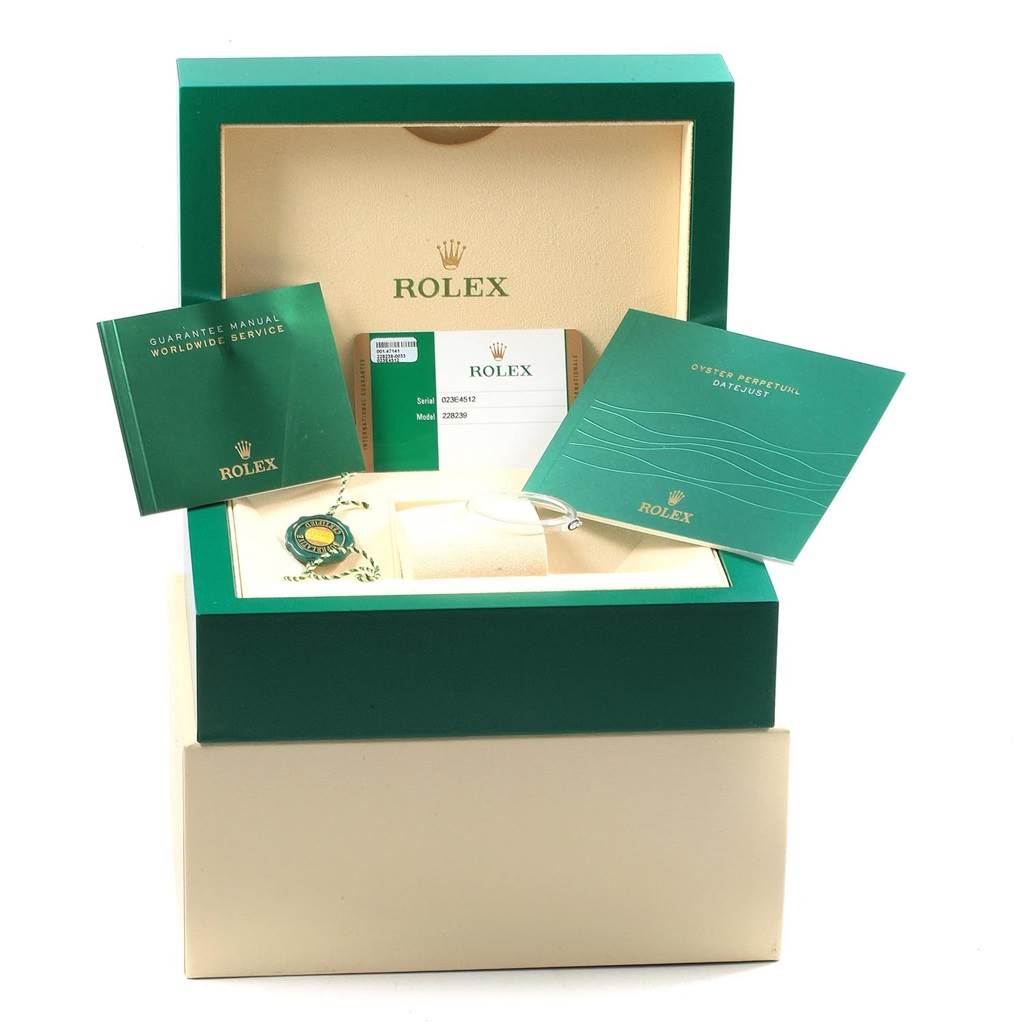 The image shows the packaging and documentation for a Rolex President 228239 Men's White Gold Silver Dial 228239 Men's White Gold Silver Dial model watch, including manuals, a warranty card, and an accessory tag.