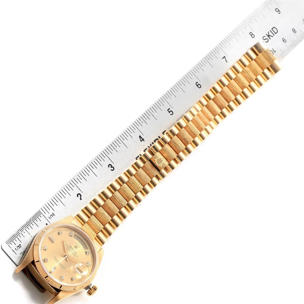 The image shows the Rolex President 18078 Men
s Yellow Gold Champagne Dial 18078 Men
s Yellow Gold Champagne Dial model watch laid flat with the band and face visible, alongside a ruler for scale.