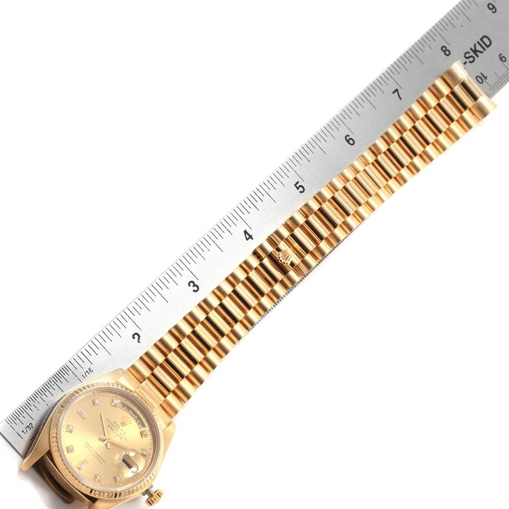 The image features a Rolex President 18038 Men
s Yellow Gold Champagne Dial 18038 Men
s Yellow Gold Champagne Dial model watch laid next to a ruler for measurement, showing the face and strap length.