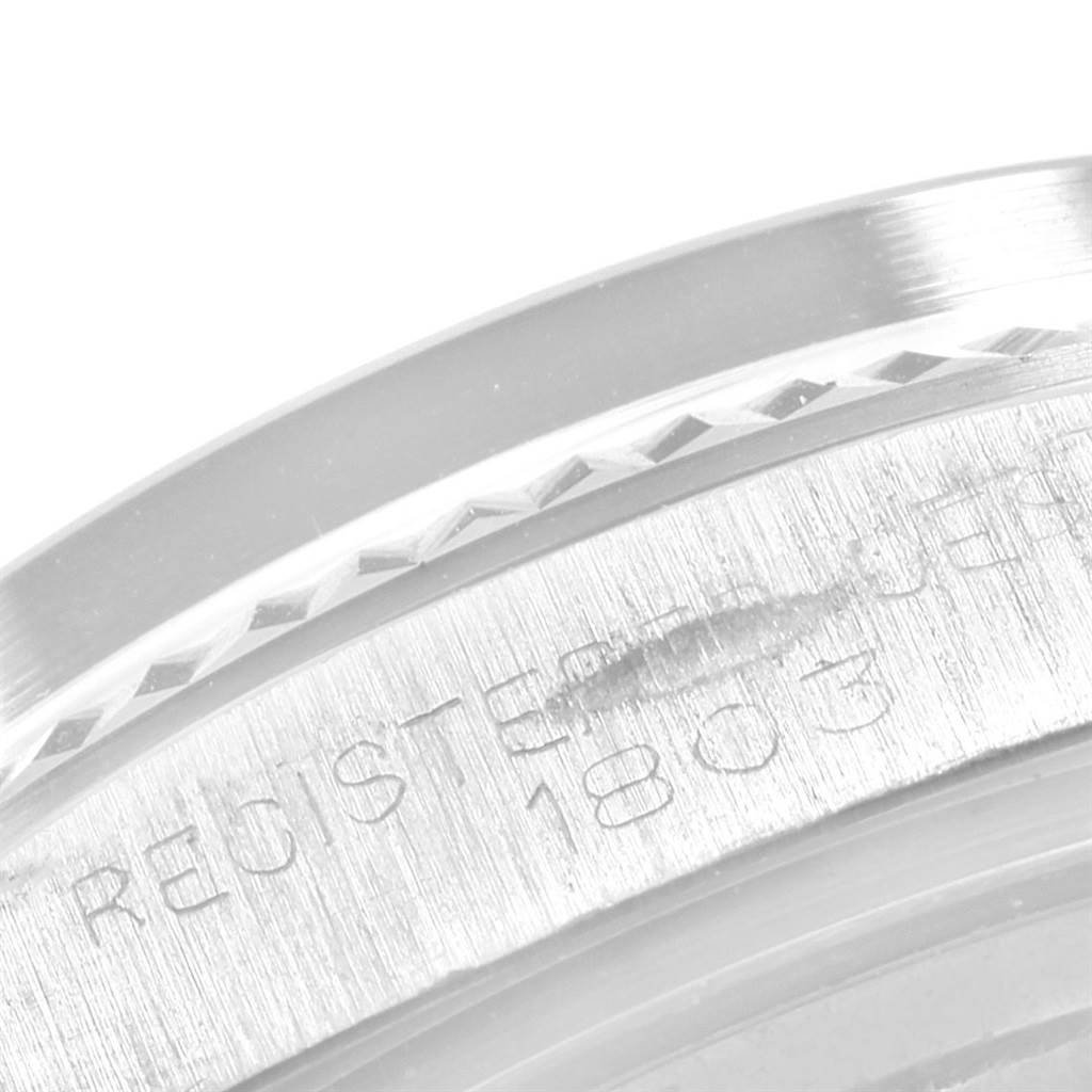 This close-up image shows the edge of the bezel and case of the Rolex President 1803 Men
s White Gold Black Dial 1803 Men
s White Gold Black Dial 1803 model, highlighting etched details.