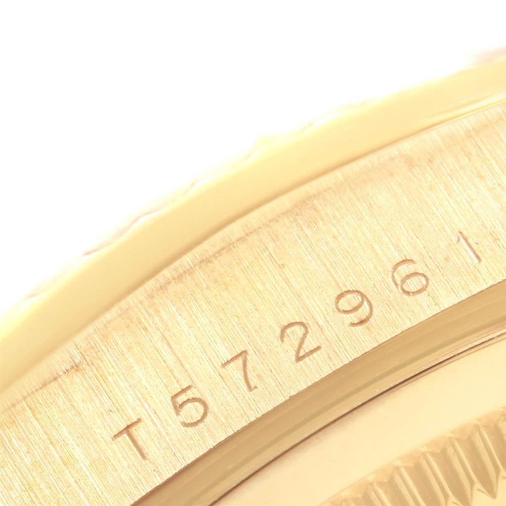 The image shows a close-up of the side of a Rolex President 20030 Men
s Yellow Gold Champagne Dial 20030 Men
s Yellow Gold Champagne Dial watch, focusing on the engraved serial number.