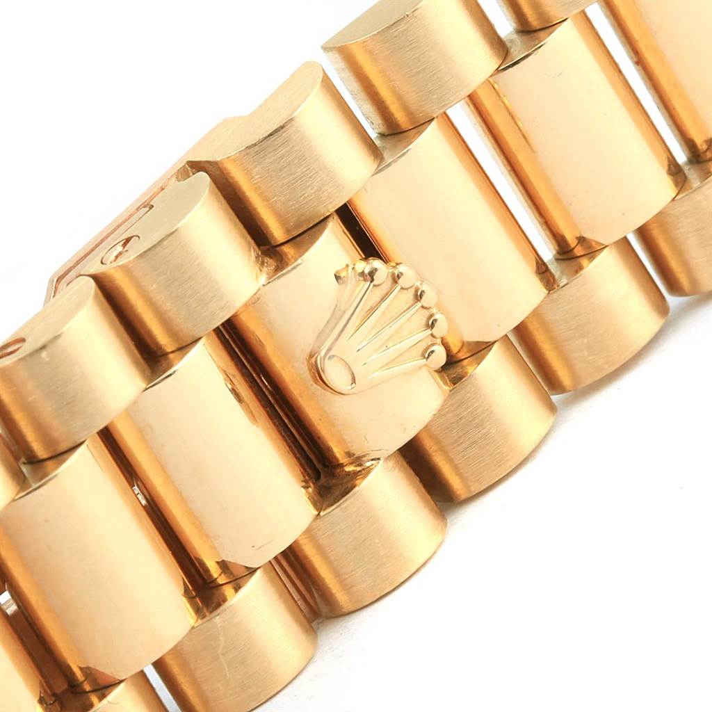 The image shows a close-up of the bracelet links and the Rolex logo on a President model by Rolex.