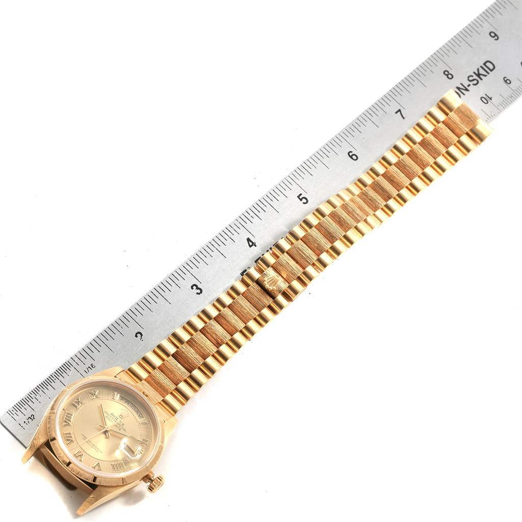The image shows a gold Rolex President 18248 Men
s Yellow Gold Champagne Dial 18248 Men
s Yellow Gold Champagne Dial model watch horizontally aligned next to a ruler, displaying the watch face and bracelet.