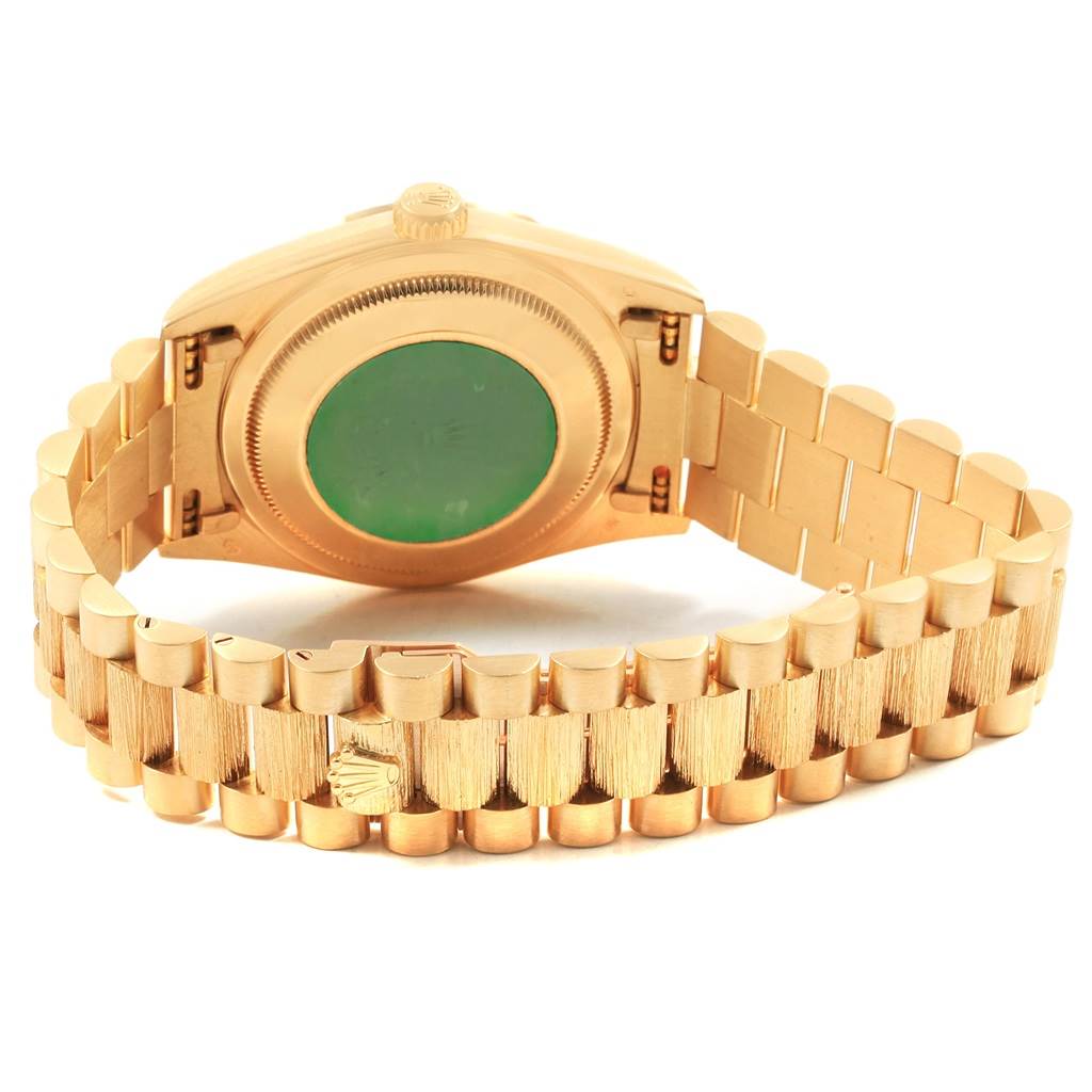The image shows the back case and bracelet of a Rolex President 18248 Men
s Yellow Gold Champagne Dial 18248 Men
s Yellow Gold Champagne Dial model watch, highlighting its green case back and gold strap.