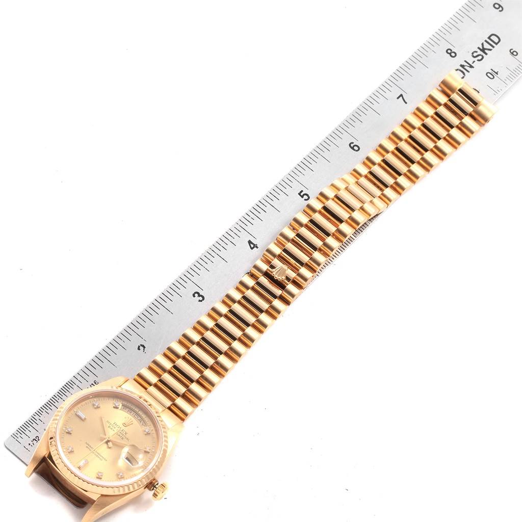 The image shows the Rolex President 18238 Men
s Yellow Gold Champagne Dial 18238 Men
s Yellow Gold Champagne Dial model watch laid flat next to a ruler, displaying the face and band.