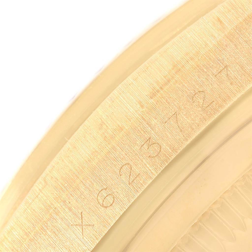 This image shows a close-up of the engraved bezel on a Rolex President 18238 Men
s Yellow Gold Champagne Dial 18238 Men
s Yellow Gold Champagne Dial model watch at an oblique angle.