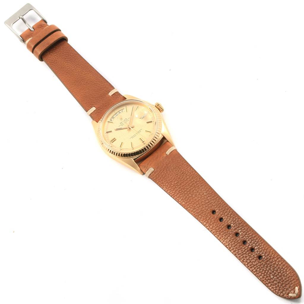 The Rolex President 1803 Men
s Yellow Gold Champagne Dial 1803 Men
s Yellow Gold Champagne Dial watch is shown at a top-down angle, highlighting its face, bezel, and brown leather strap.