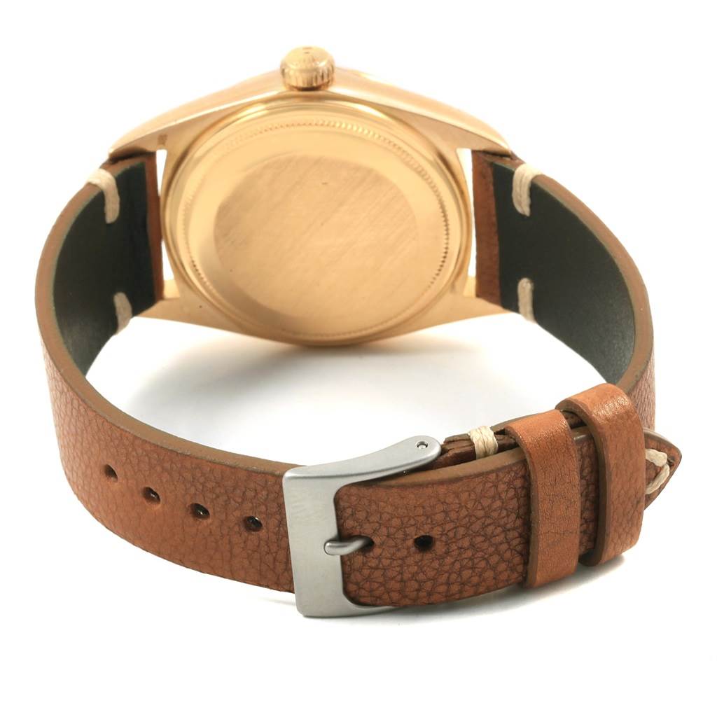 The image shows the back view of the Rolex President 1803 Men
s Yellow Gold Champagne Dial 1803 Men
s Yellow Gold Champagne Dial model watch, highlighting the case back and leather strap with buckle.