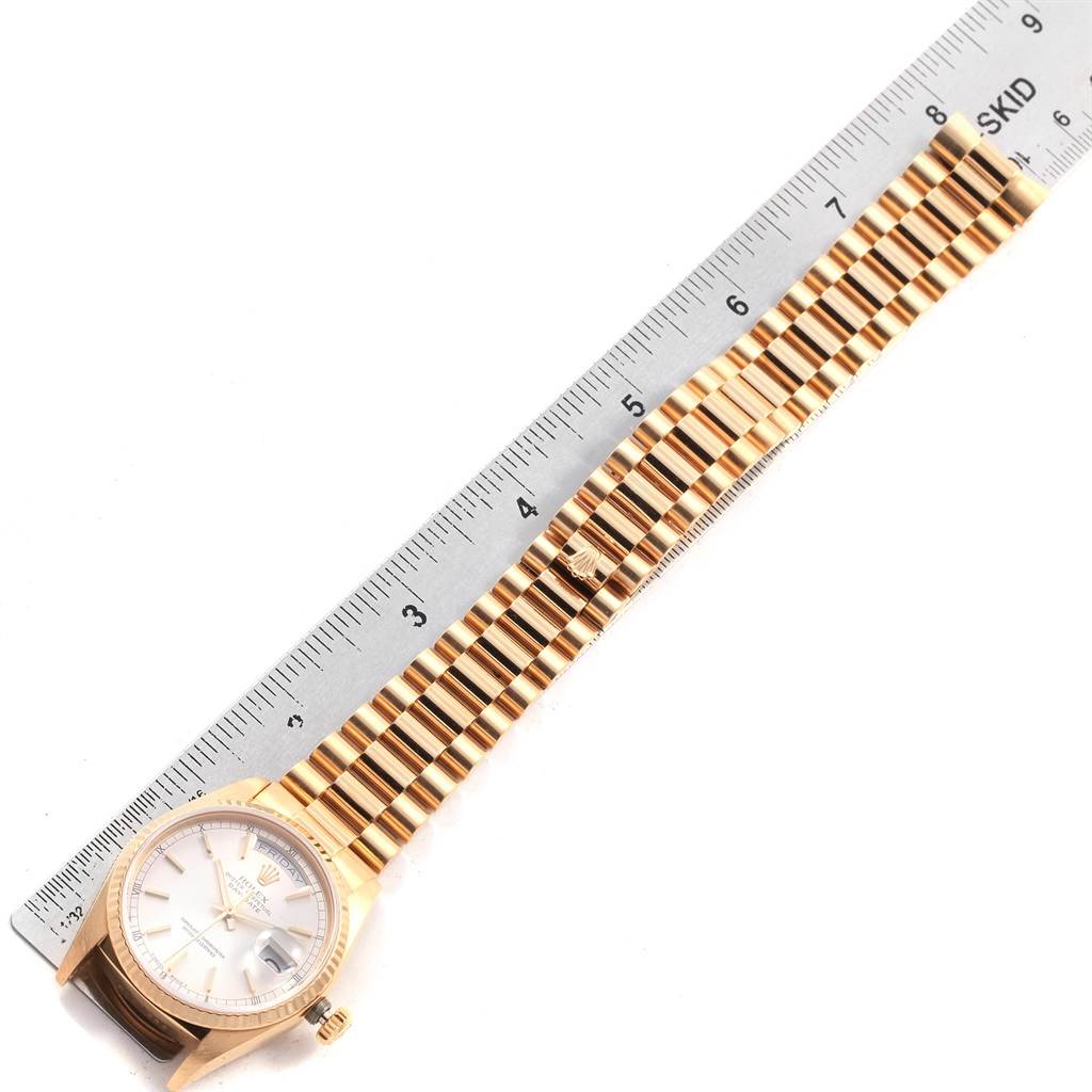 The Rolex President 18038 Men
s Yellow Gold Silver Dial 18038 Men
s Yellow Gold Silver Dial model watch is shown from a top-down angle, displaying the face and entire bracelet alongside a ruler for scale.