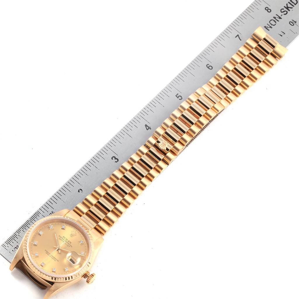 This image shows a top-down view of a Rolex President 16238 Men
s Yellow Gold Champagne Dial 16238 Men
s Yellow Gold Champagne Dial model watch, including its face and full bracelet next to a ruler.