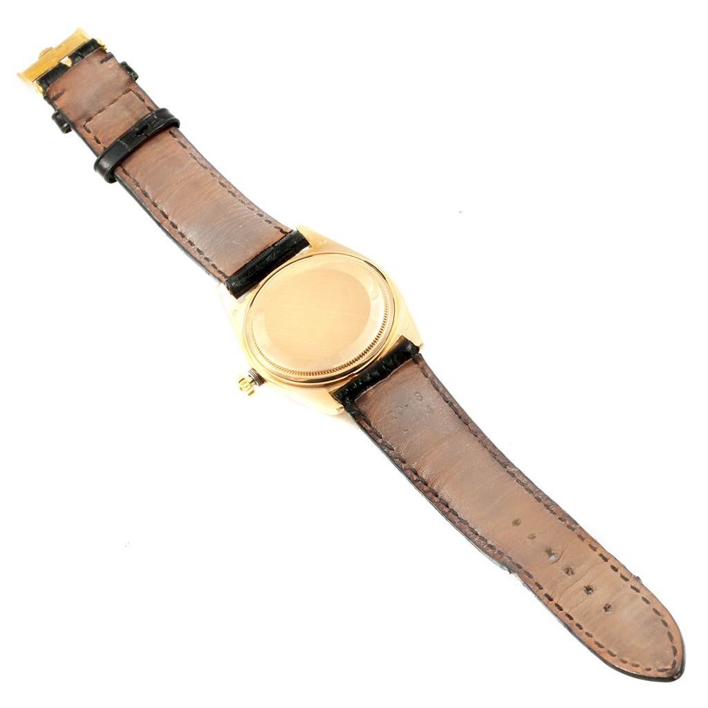 The image shows the back and leather strap of a Rolex President 1803 Men
s Yellow Gold Black Dial 1803 Men
s Yellow Gold Black Dial model watch from an overhead angle.