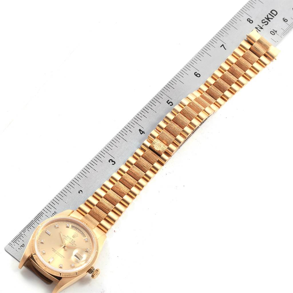The image shows the Rolex President 20604 Men
s Yellow Gold Champagne Dial 20604 Men
s Yellow Gold Champagne Dial model watch laid flat with its band measured against a ruler.