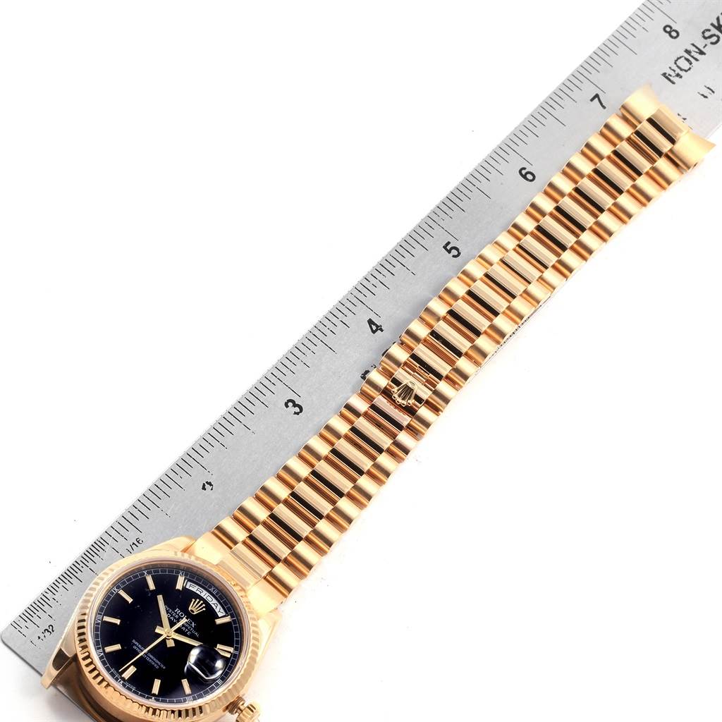 The image shows a top view of a Rolex President 118238 Men's Yellow Gold Black Dial 118238 Men's Yellow Gold Black Dial model watch, highlighting its band and face against a ruler for scale.