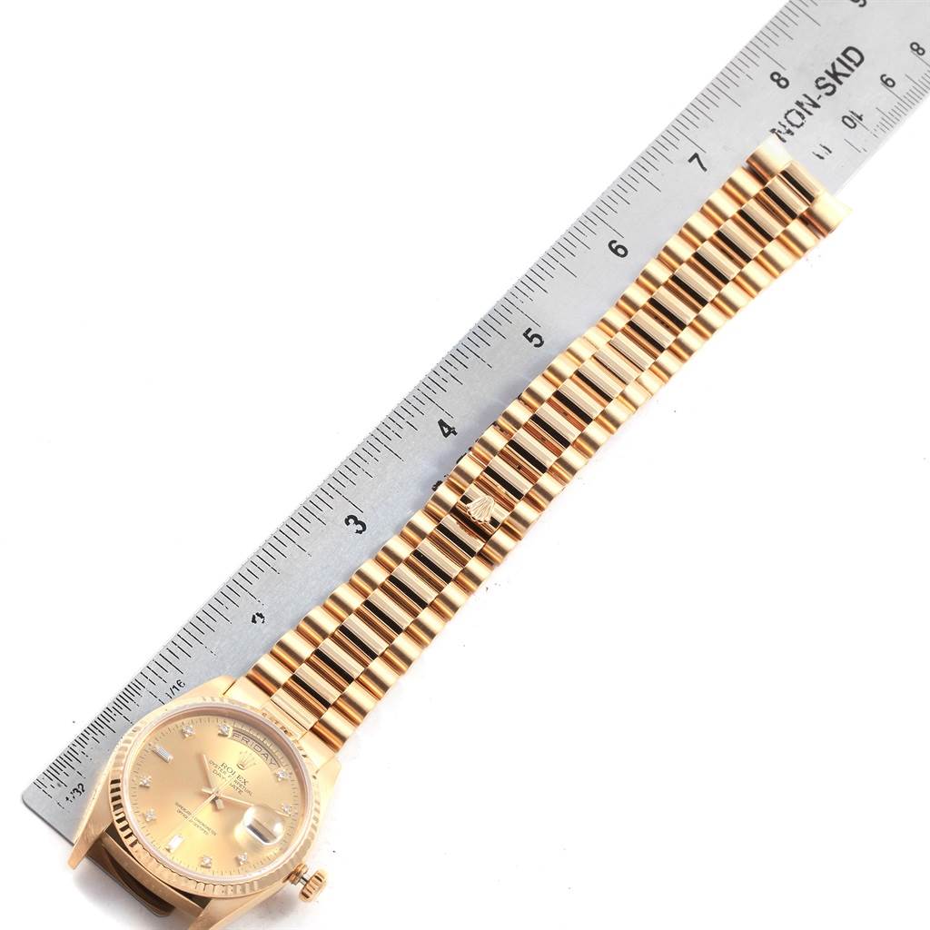 The image displays a Rolex President 18238 Men
s Yellow Gold Champagne Dial 18238 Men
s Yellow Gold Champagne Dial model watch with its gold dial, gold bracelet, and placed next to a ruler for measurement.