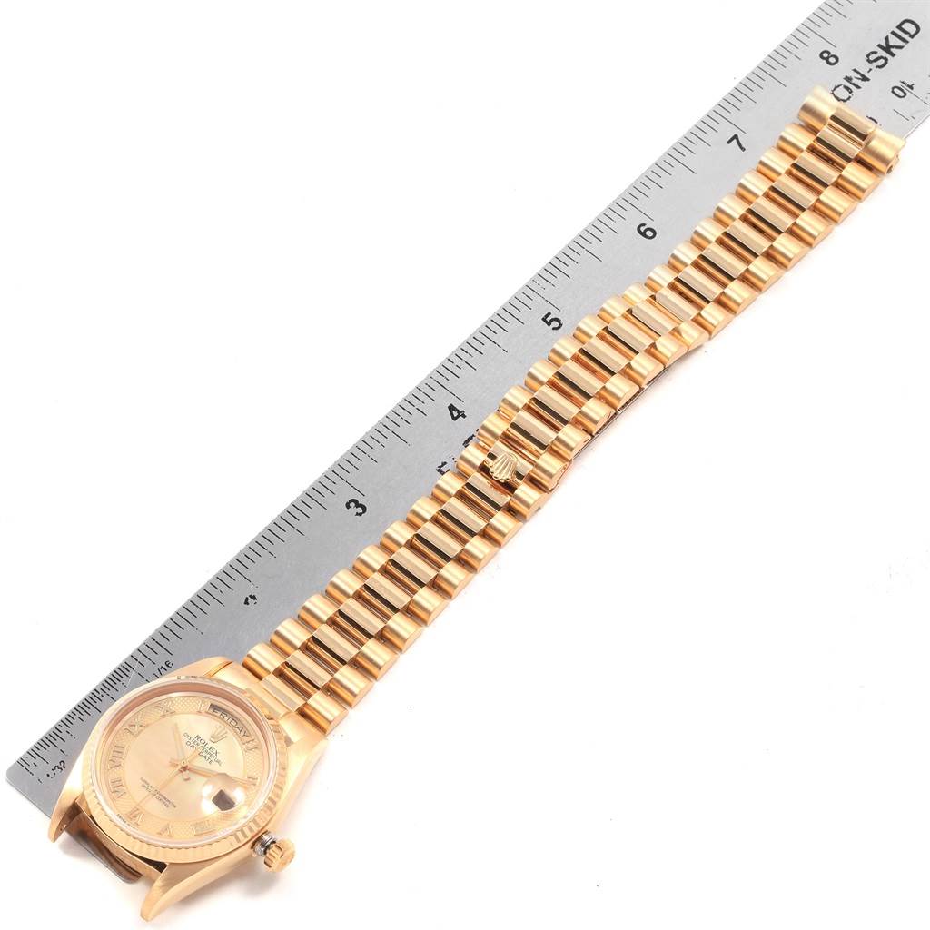 This image shows the whole Rolex President 18038 Men
s Yellow Gold Mother of Pearl Dial 18038 Men
s Yellow Gold Mother of Pearl Dial model watch, including its face and band, measured against a ruler.