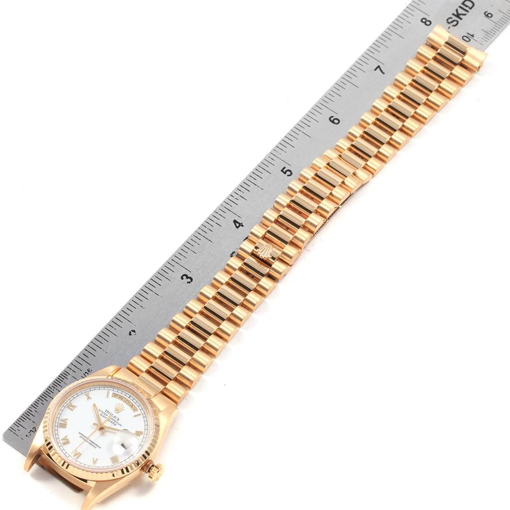 This image shows a Rolex President 18238 Men
s Yellow Gold White Dial 18238 Men
s Yellow Gold White Dial model watch placed alongside a ruler for measurement, viewed from above.