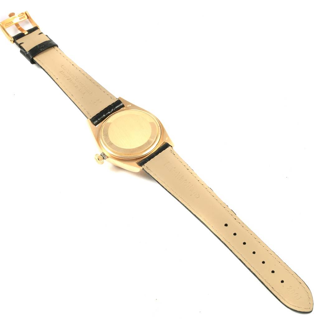 The image shows the backside of the Rolex President 18038 Men
s Yellow Gold Champagne Dial 18038 Men
s Yellow Gold Champagne Dial model watch, highlighting its caseback and leather strap.