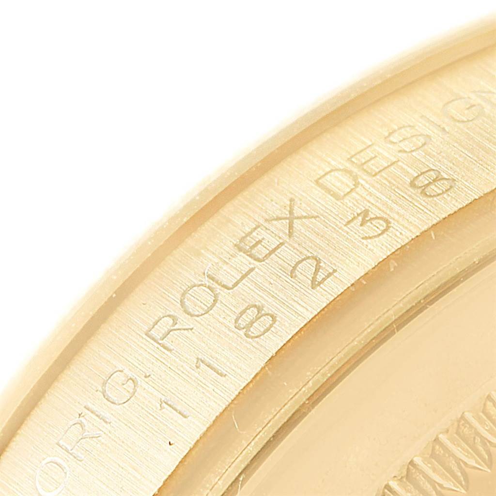 This image shows a close-up of the engraved bezel on a Rolex President 118238 Men's Yellow Gold Silver Dial 118238 Men's Yellow Gold Silver Dial model watch.