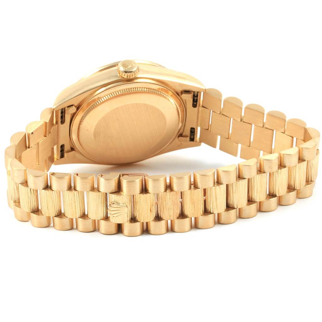 The image shows the back case and bracelet of an upside-down Rolex President 18138 Men
s Yellow Gold Champagne Dial 18138 Men
s Yellow Gold Champagne Dial model in gold.