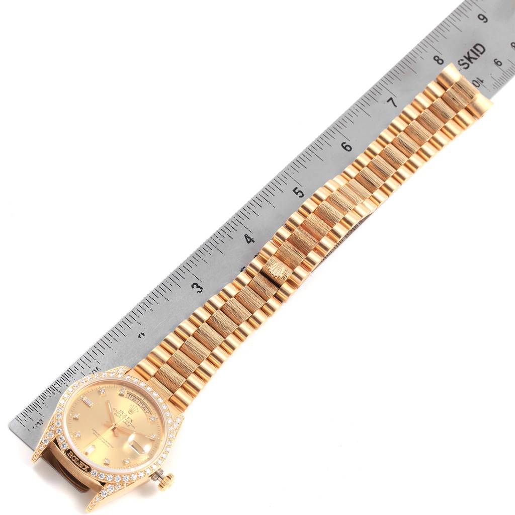 The image shows a Rolex President 18138 Men
s Yellow Gold Champagne Dial 18138 Men
s Yellow Gold Champagne Dial model watch laid flat next to a ruler, highlighting the watch face and bracelet.