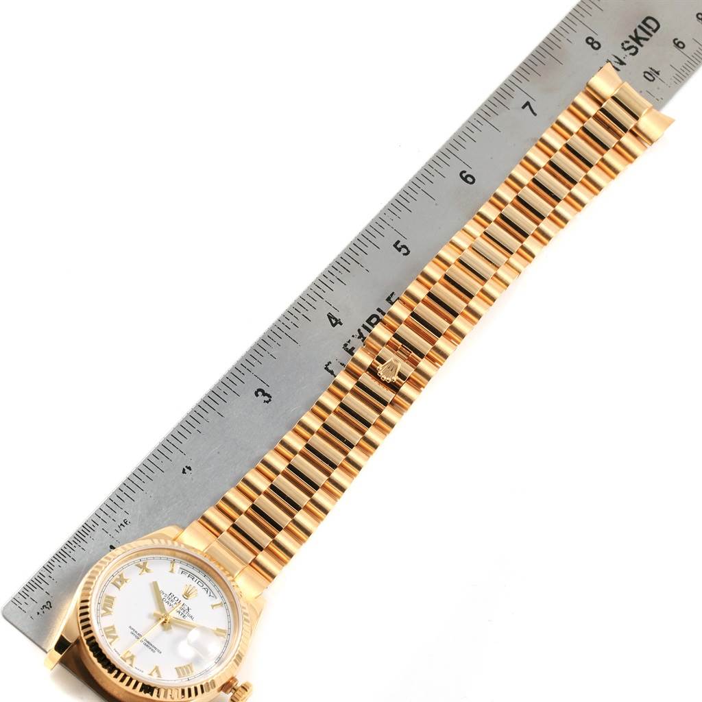 This image shows the gold bracelet and face of a Rolex President 118238 Men's Yellow Gold White Dial 118238 Men's Yellow Gold White Dial model watch with a ruler for measurement.