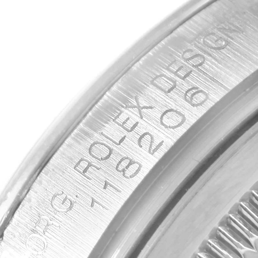 The image shows a close-up of the edge of the case back of a Rolex President 118206 Men's Platinum Blue Dial 118206 Men's Platinum Blue Dial model watch, including the engraving.