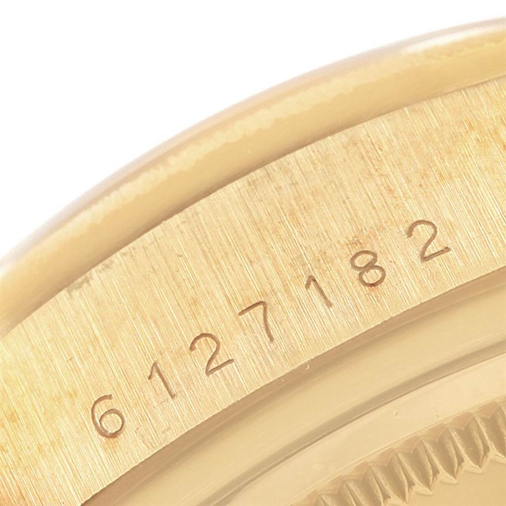 This close-up image shows part of the gold case and the serial number of a Rolex President 18078 Men's Yellow Gold Champagne Dial 18078 Men's Yellow Gold Champagne Dial model watch.