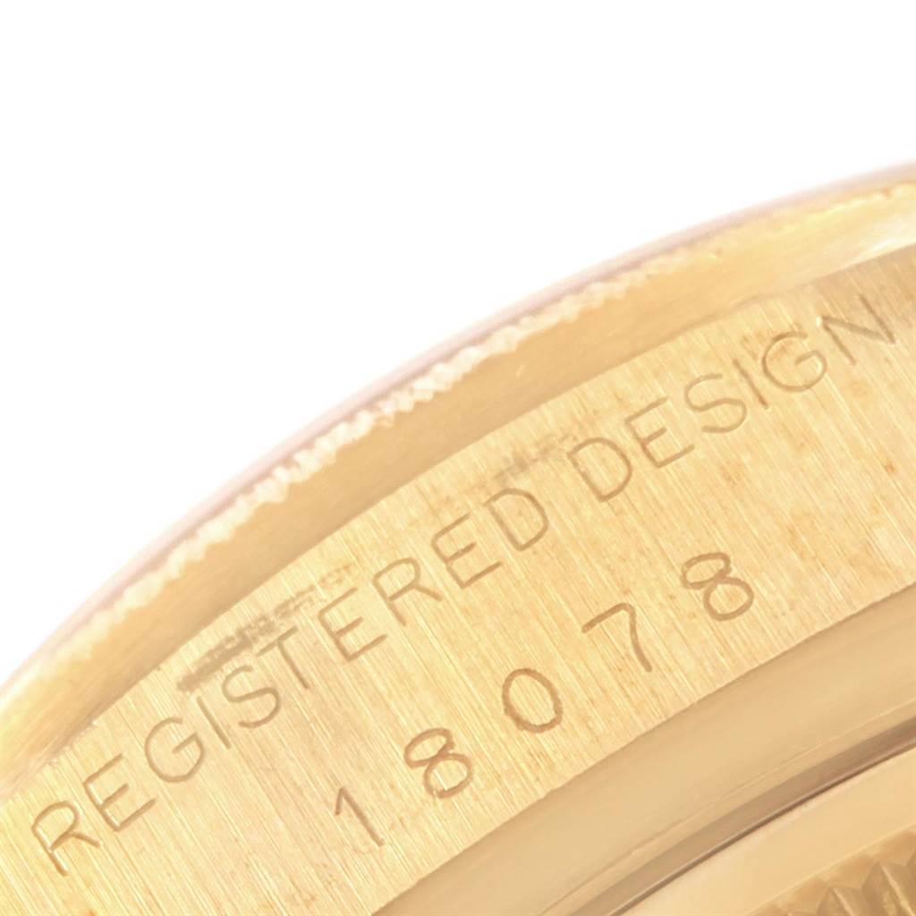 This close-up image shows part of the case back of a Rolex President 18078 Men's Yellow Gold Champagne Dial 18078 Men's Yellow Gold Champagne Dial model watch, with "REGISTERED DESIGN 18078" engraved.