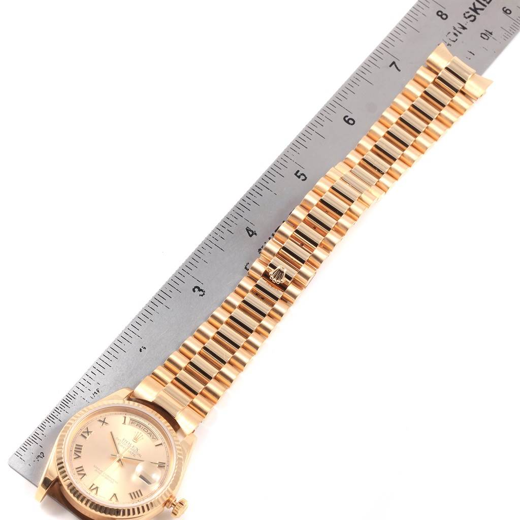 The image shows a Rolex President 118238 Men
s Yellow Gold Champagne Dial 118238 Men
s Yellow Gold Champagne Dial model watch laid flat with its bracelet next to a ruler.