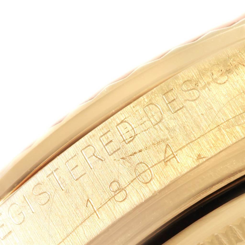 This close-up image shows a part of the bezel and engraved edge of a Rolex President 1804 Men
s Yellow Gold Champagne Dial 1804 Men
s Yellow Gold Champagne Dial model watch.