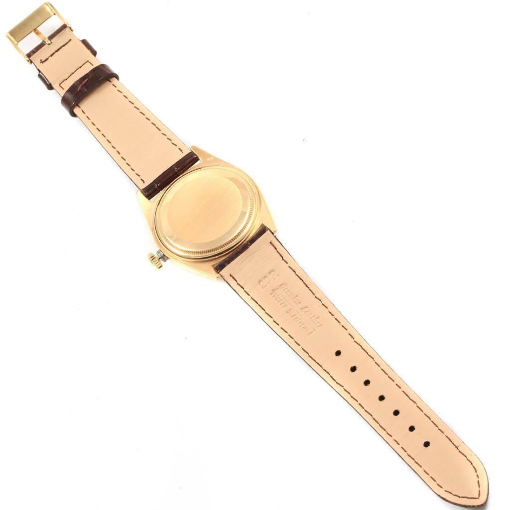 This image shows the back case and leather strap of a Rolex President 1804 Men
s Yellow Gold Champagne Dial 1804 Men
s Yellow Gold Champagne Dial model watch from a top-down angle.