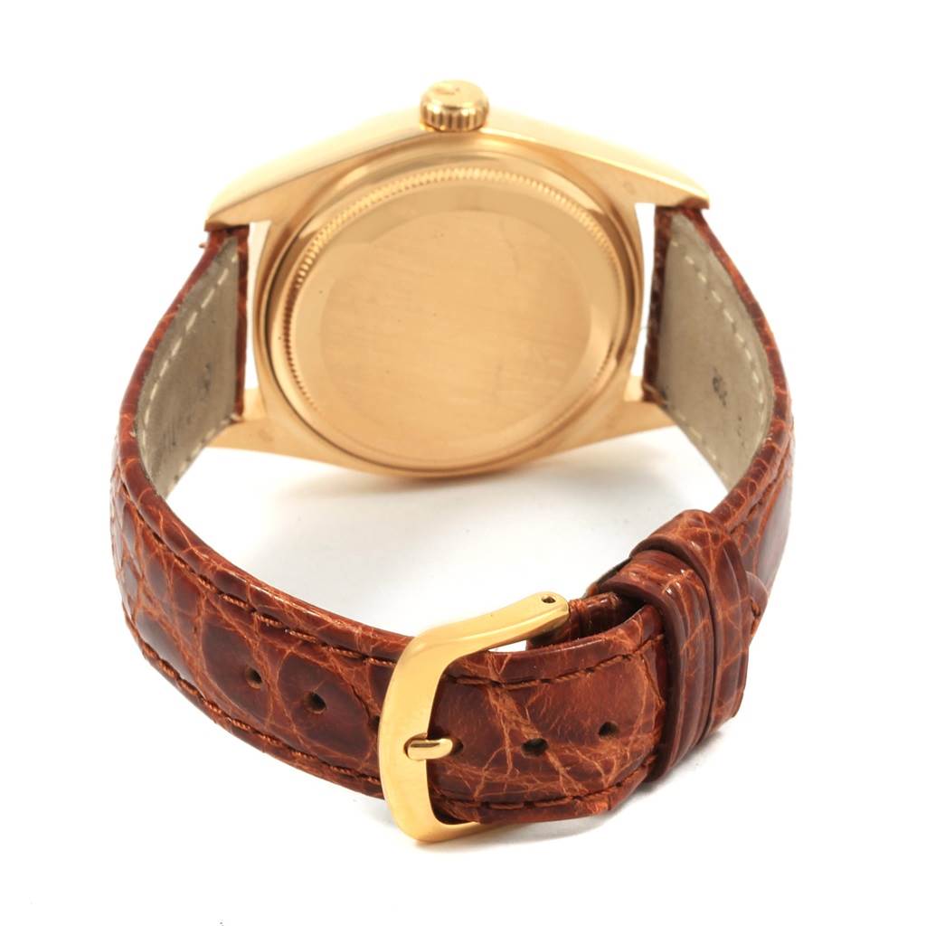 The image shows the back of the Rolex President 18038 Men
s Yellow Gold Champagne Dial 18038 Men
s Yellow Gold Champagne Dial watch case and its brown leather strap with a gold buckle.