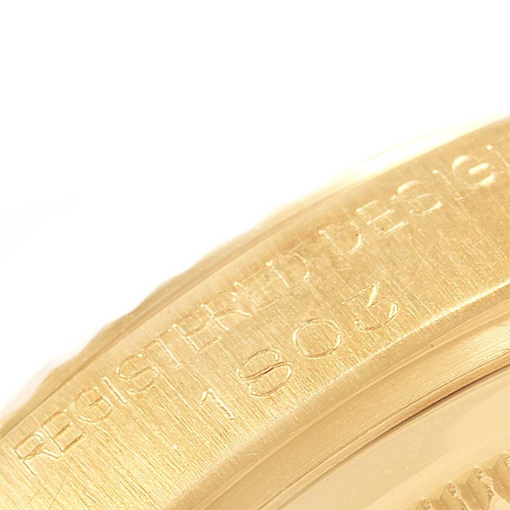 The image shows a close-up angle of the bezel and part of the dial of the Rolex President 1803 Men's Yellow Gold Champagne Dial 1803 Men's Yellow Gold Champagne Dial model, highlighting the etched design registration number.