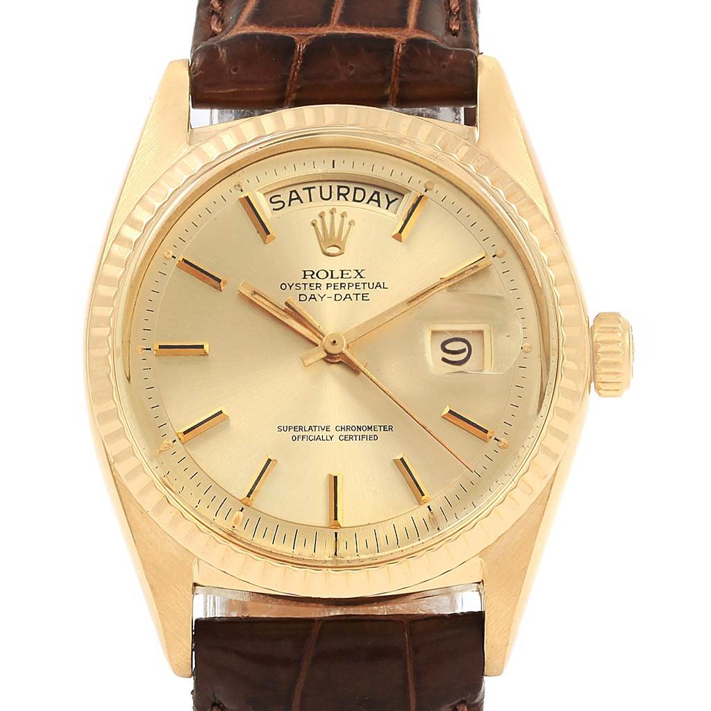 The image shows a Rolex President 1807 Men
s Yellow Gold Champagne Dial 1807 Men
s Yellow Gold Champagne Dial Day-Date watch with a gold case, brown leather strap, and day and date windows, viewed from the front.