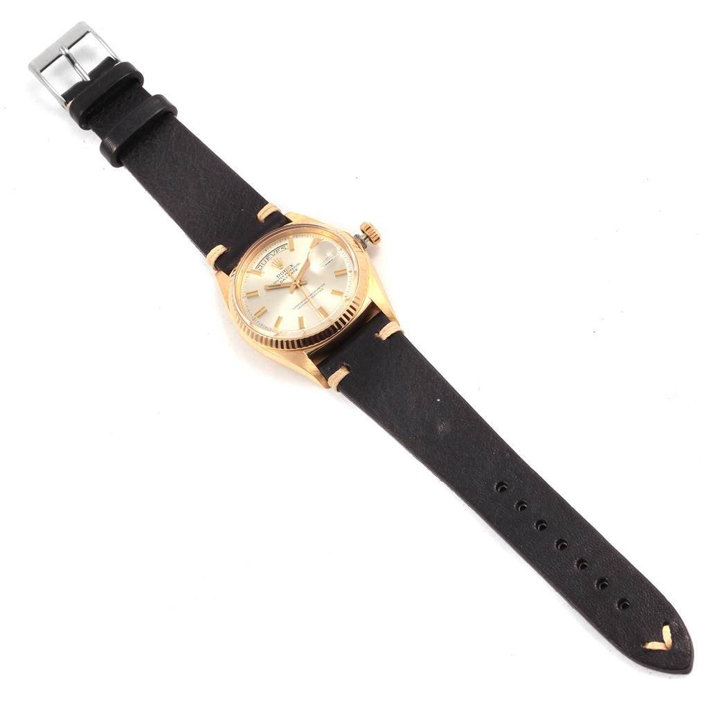 The Rolex President 1803 Men
s Yellow Gold Silver Dial 1803 Men
s Yellow Gold Silver Dial model watch is shown from a top-down angle, featuring its dial, bezel, crown, and black leather strap.