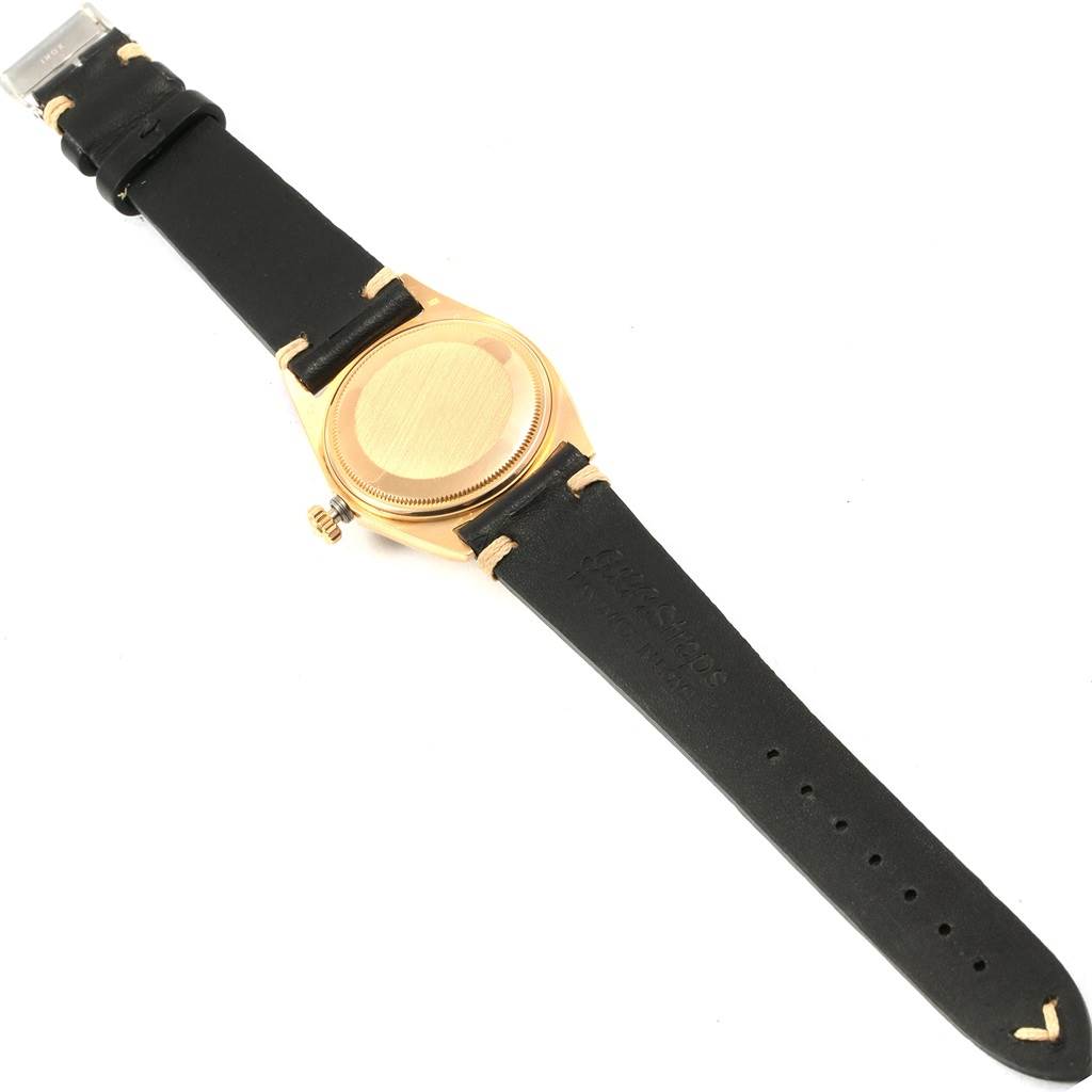 This image shows the back case and black leather strap of a Rolex President 1803 Men
s Yellow Gold Silver Dial 1803 Men
s Yellow Gold Silver Dial model watch from a top-down view.