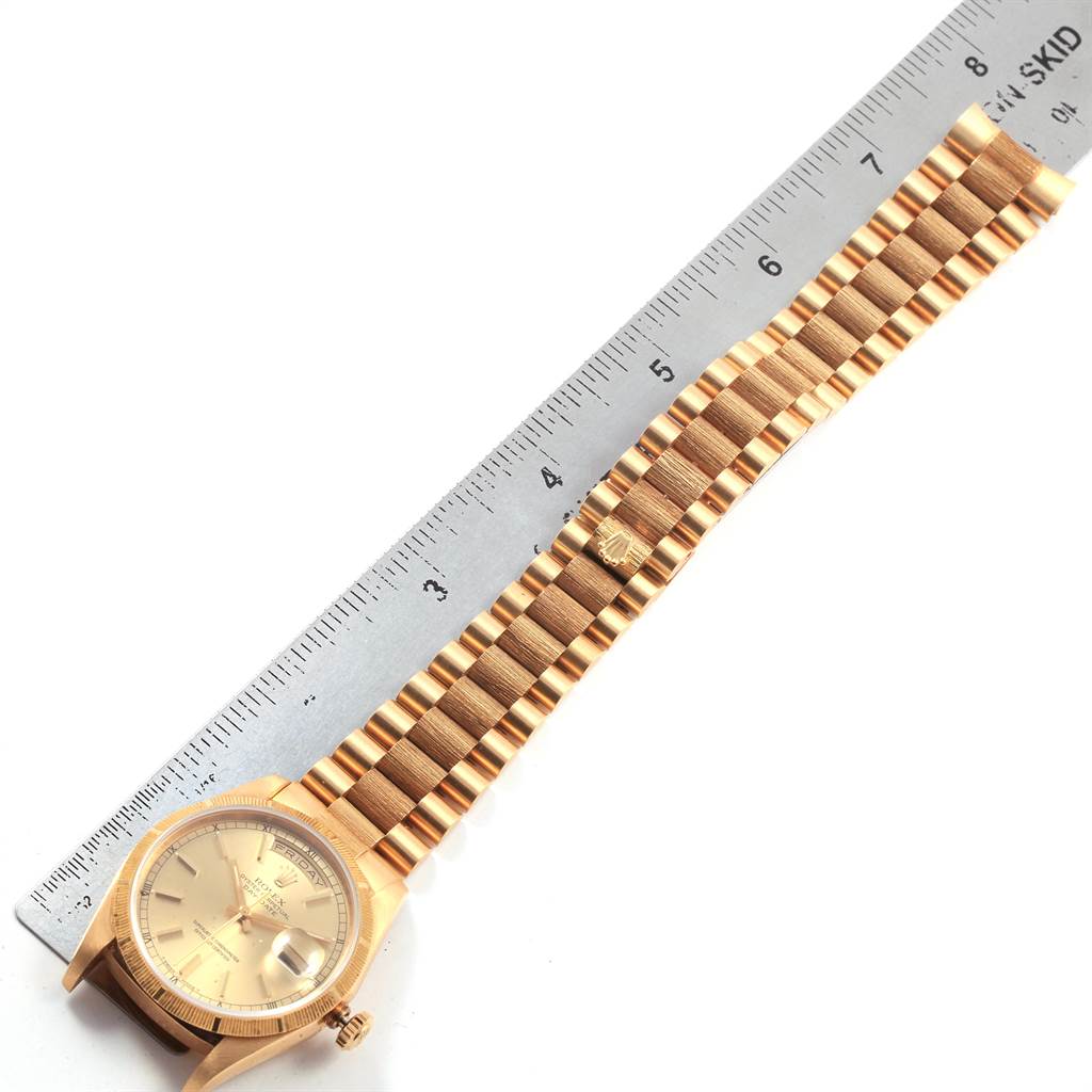 The image shows the Rolex President 18248 Men
s Yellow Gold Champagne Dial 18248 Men
s Yellow Gold Champagne Dial model watch laid flat with a ruler for scale, highlighting the watch
s face and bracelet.
