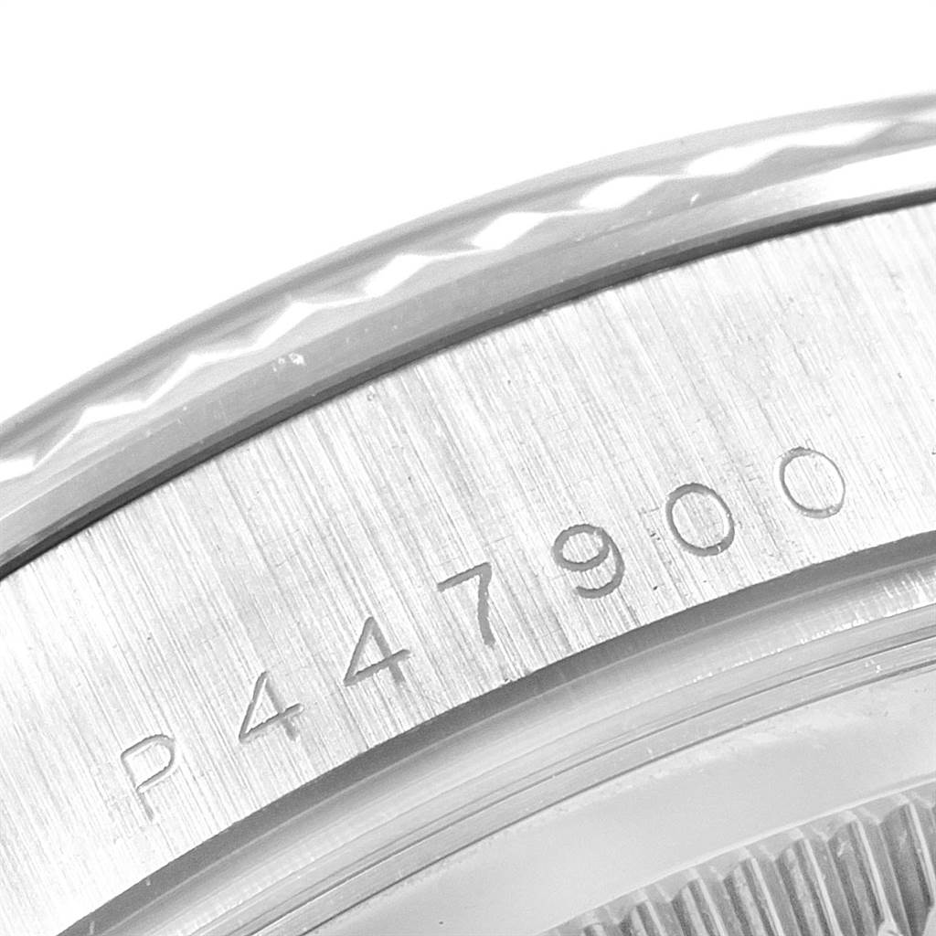 A close-up of the Rolex President 118239 Men's White Gold Silver Dial 118239 Men's White Gold Silver Dial watch showing part of the bezel and serial number engraving.