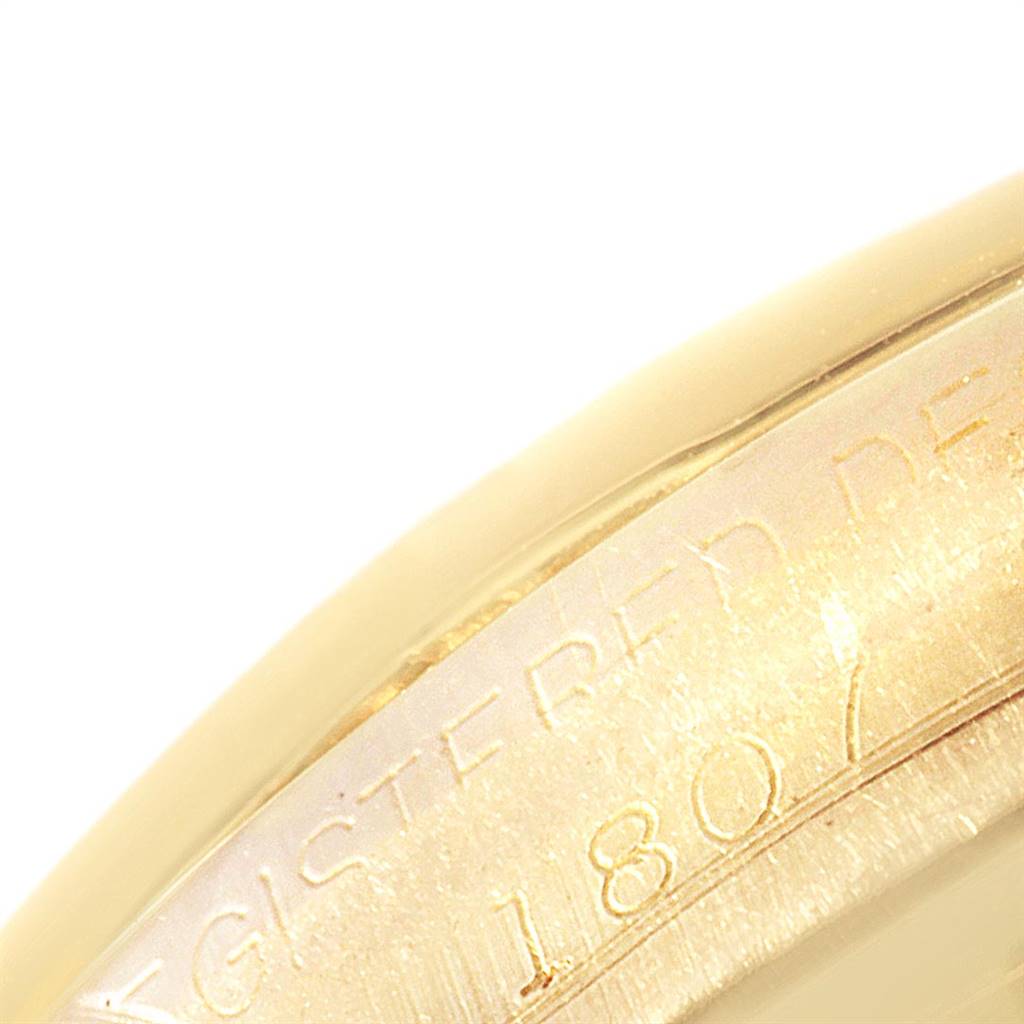 This close-up image shows the side of the case of a Rolex President 1807 Men
s Yellow Gold Champagne Dial 1807 Men
s Yellow Gold Champagne Dial watch, including part of the engraved serial number.