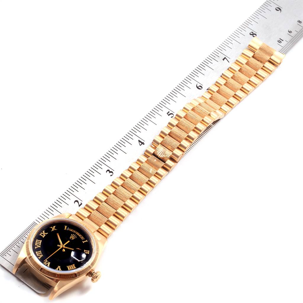 The image shows a Rolex President 18248 Men
s Yellow Gold Black Dial 18248 Men
s Yellow Gold Black Dial model watch laid flat, with the watch face, bracelet, and clasp visible, alongside a ruler.