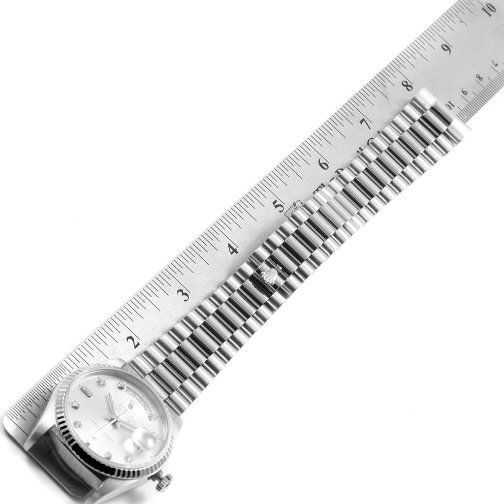 This image shows the Rolex President 18239 Men's White Gold Silver Dial 18239 Men's White Gold Silver Dial watch laid flat with its band measured against a ruler.