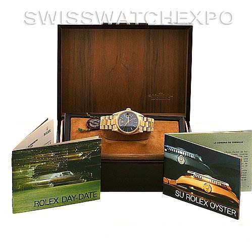 The Rolex President 18038 Men's Yellow Gold Blue Dial 18038 Men's Yellow Gold Blue Dial model watch is displayed head-on in an open wooden box, accompanied by Rolex Day-Date and Rolex Oyster booklets.